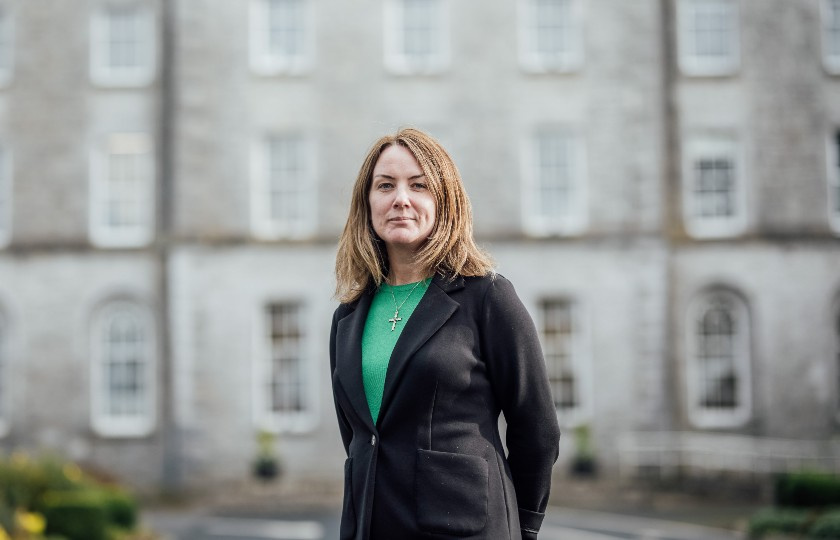 Dr Hannagh McGinley standing in front of a campus building