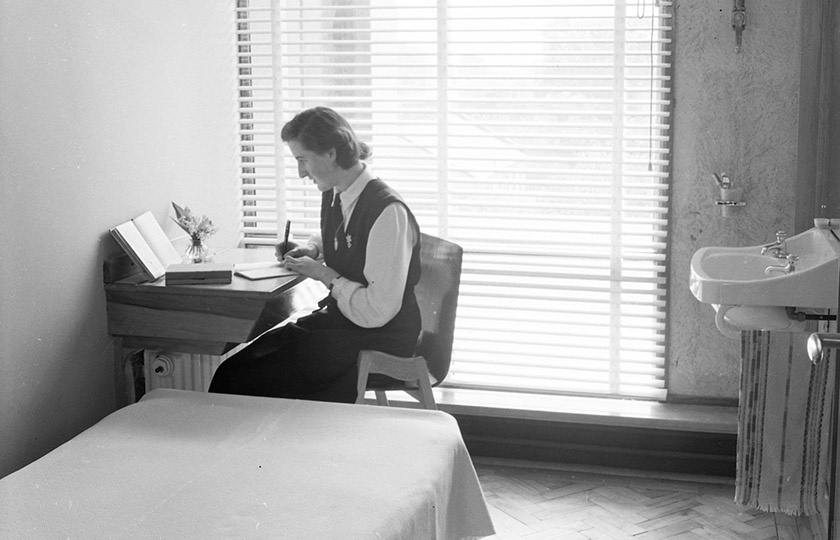 Student sitting at a desk in her bedroom in the new residential block at MIC in 1957.
