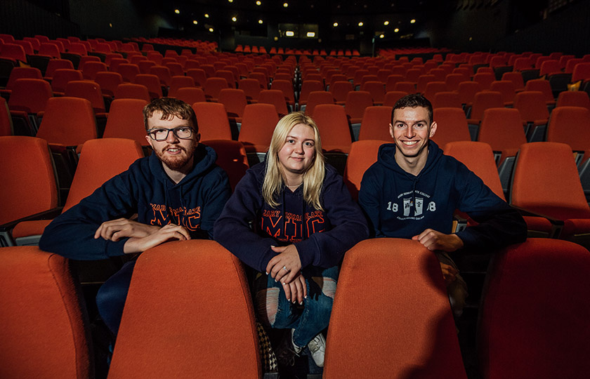 Three students sitting in an empty Lime Tree theatre 