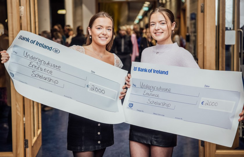 Twins Niamh and Tara Ryan holding prop cheques at the College Awards ceremony