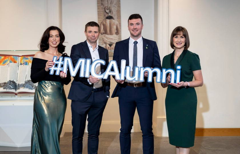 Four MIC Alumni of the Year holding a sign saying #MICAlumni