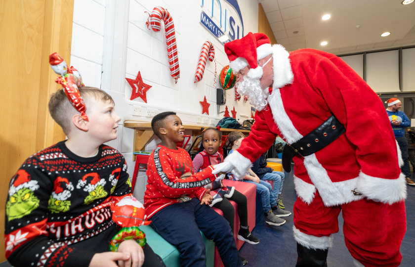 Santa greeting kids at the Christmas picnic