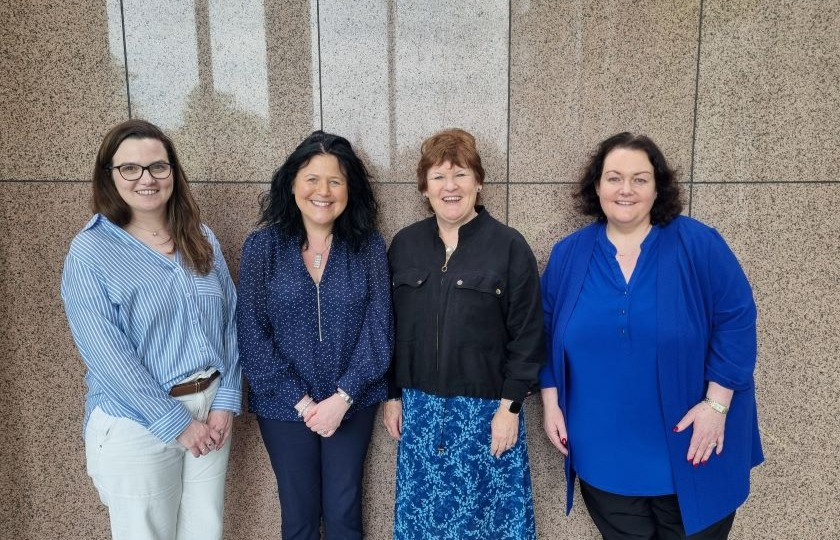 A photo of Dr Laura Costelloe, Dr Ann Marie Farrell, Dr Anna Logan and Dr Jean Reale, standing side by side at the entrance to the MIC main building.
