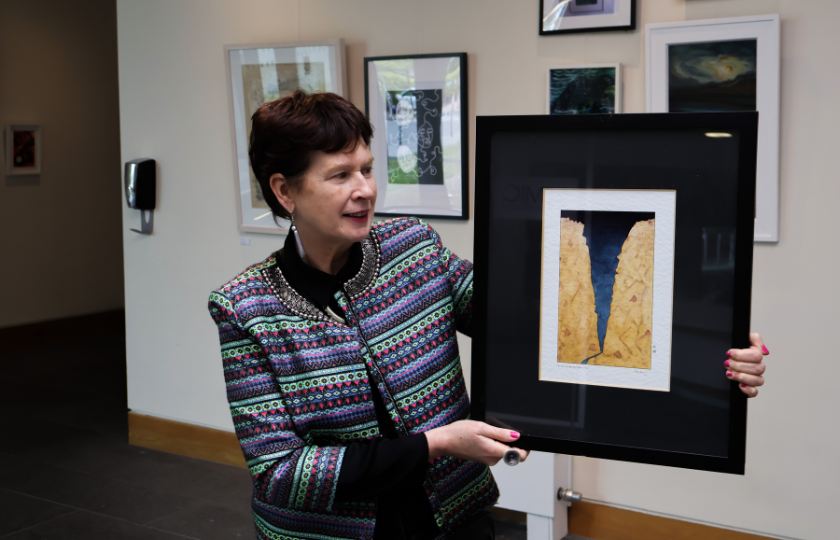 Dr Patricia Kieran holding one of de’ Angeli's paintings