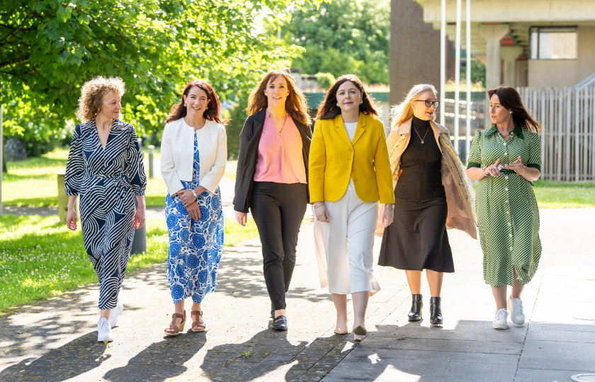 Six women involved with the PATH 1 Symposium walking towards the photographer