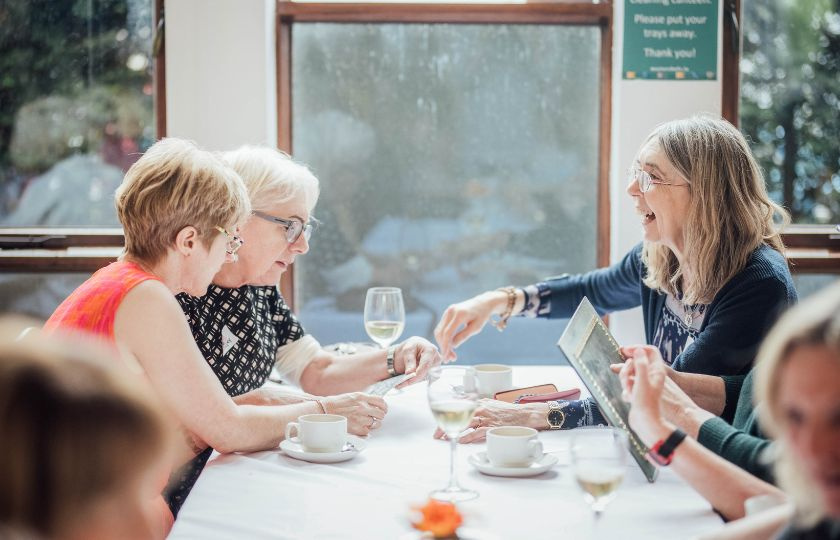 3 women sitting at a table reminiscing about their student days 