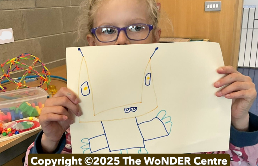 Child holds up drawing
