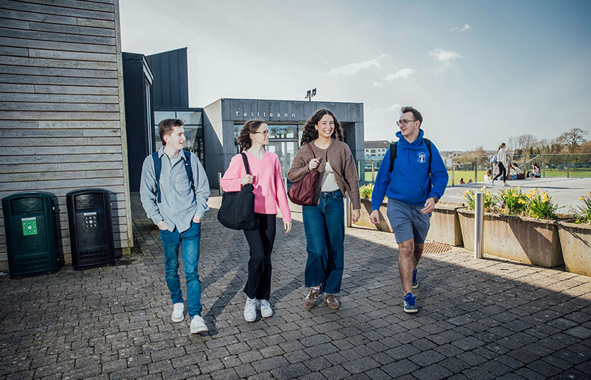 Four students walking together outside Tailteann building.