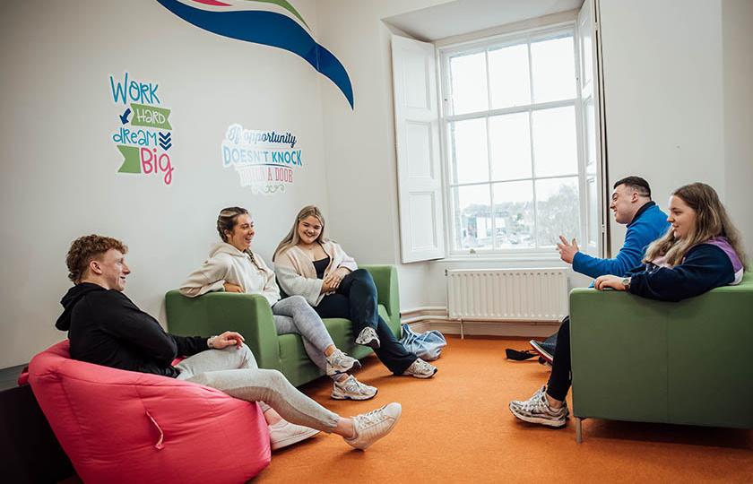 5 students chatting in student lounge