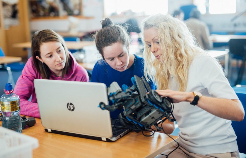 Students and lecturer looking at robotics