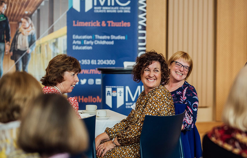 Women smiling at the alumni reunion celebration in the Halla at MIC
