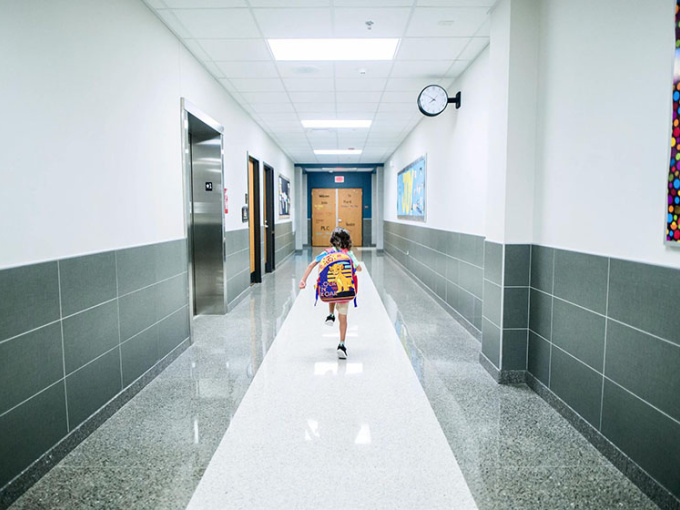 child running in empty school hallway