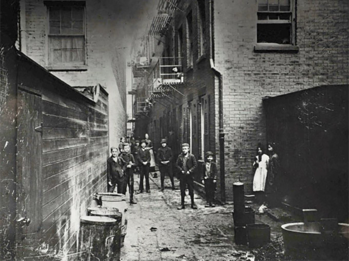 Black and white photo of young people standing in a laneway