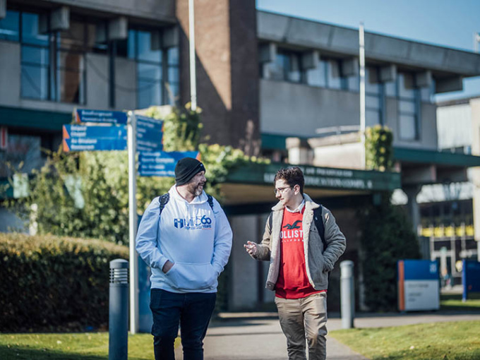 Undergraduate students walking outside the MIC library
